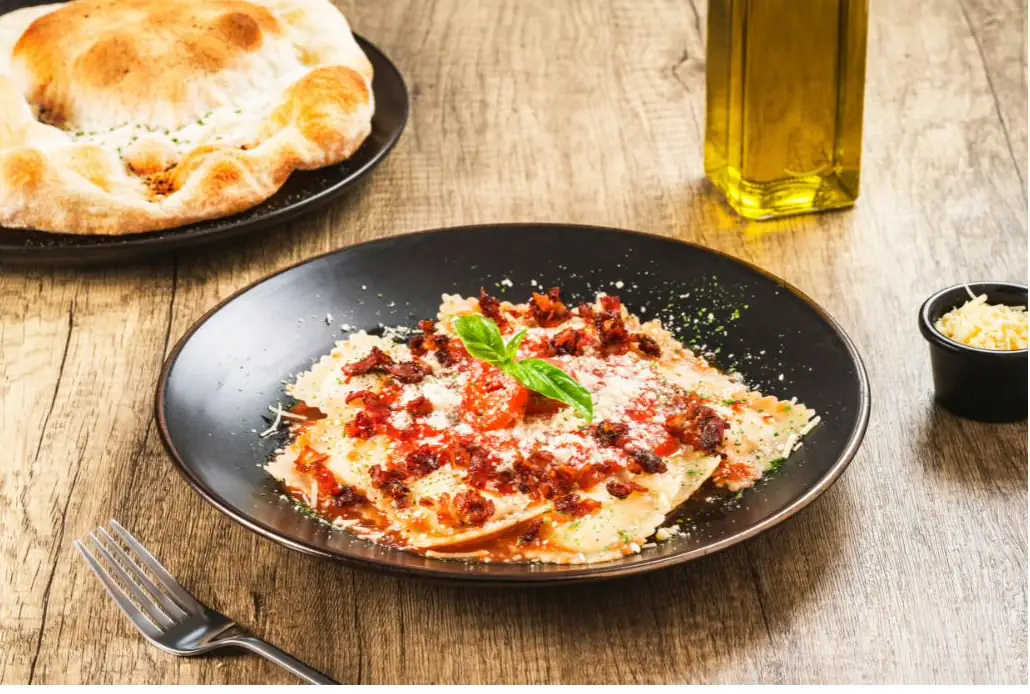 Raviolis cuatro quesos en salsa amatriciana con albahaca y pan de la casa